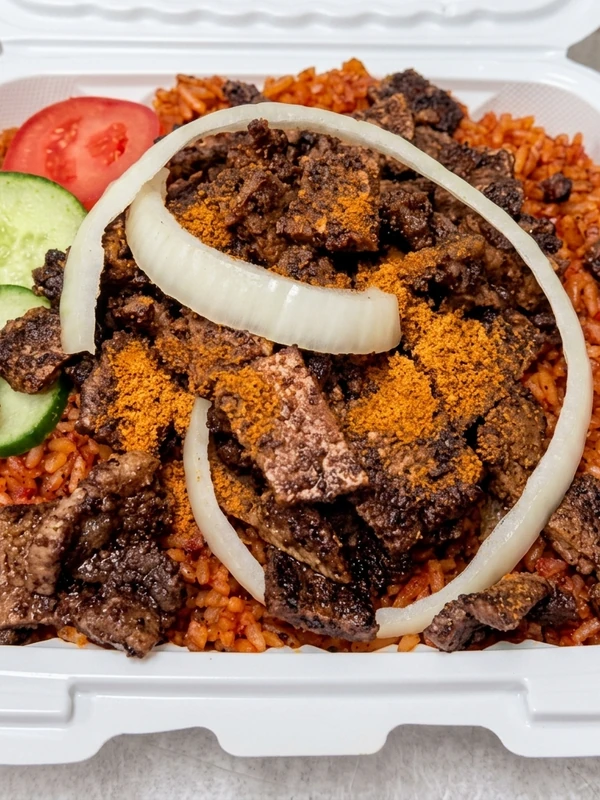 Nigerian jollof rice topped with spiced beef suya at Lagos Flavors in Edmonton, AB