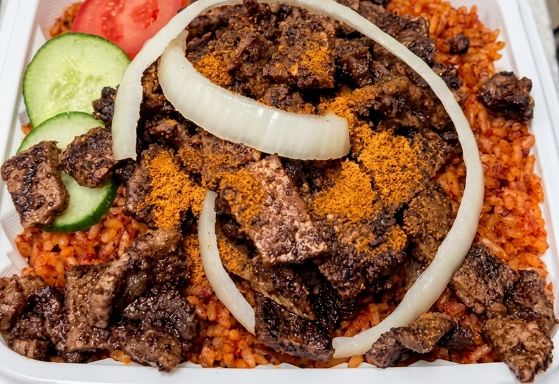Nigerian jollof rice topped with spiced beef suya at Lagos Flavors in Edmonton, AB