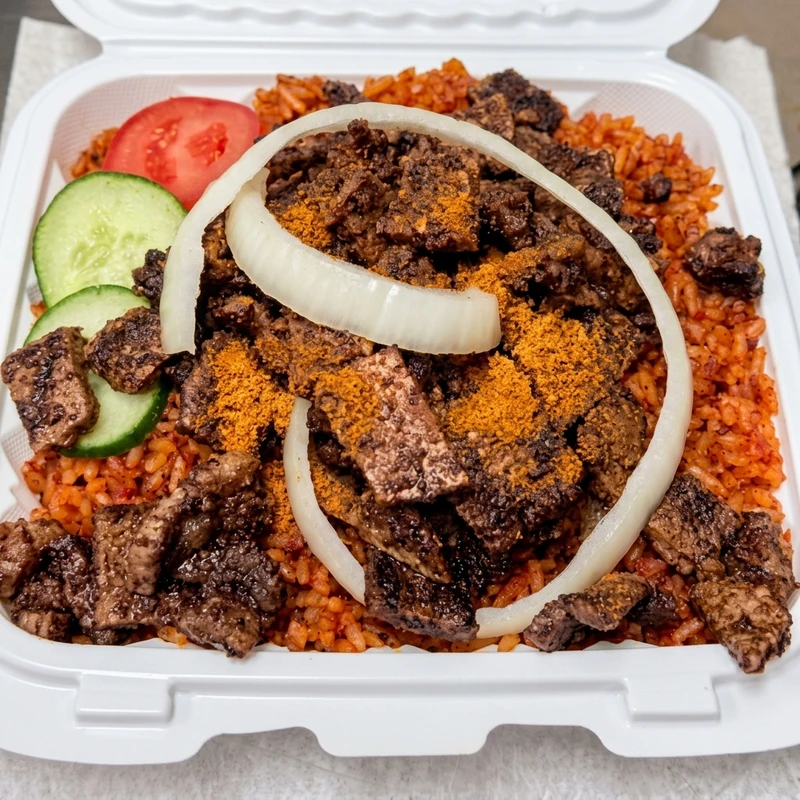 Nigerian jollof rice topped with spiced beef suya at Lagos Flavors in Edmonton, AB
