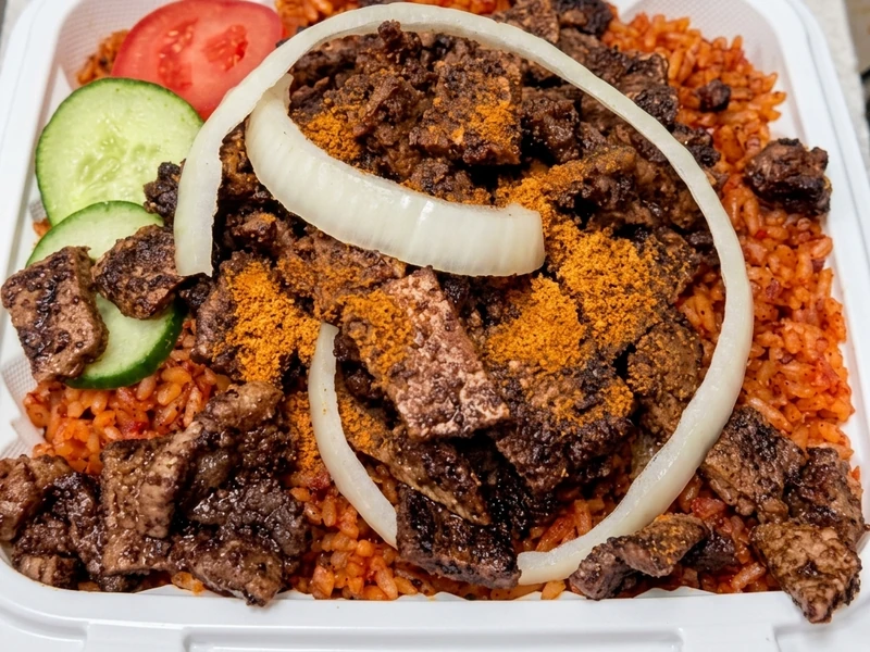 Nigerian jollof rice topped with spiced beef suya at Lagos Flavors in Edmonton, AB